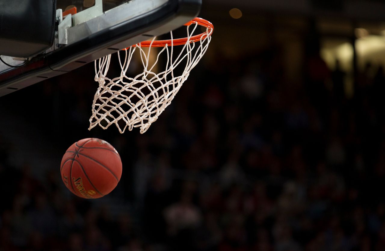 Services A basketball going through the hoop during a fast-paced game, capturing the excitement of the sport.